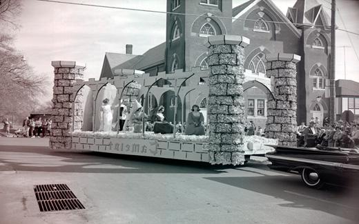 A Camelot float filled with lovely medieval-dressed Northwest students is paraded down a Maryville Street.  Camelot, due to the Kennedys and the musical, was a popular theme during the early 1960s.  Camelot, the musical about King Arthur, first appeared on Broadway in 1960.