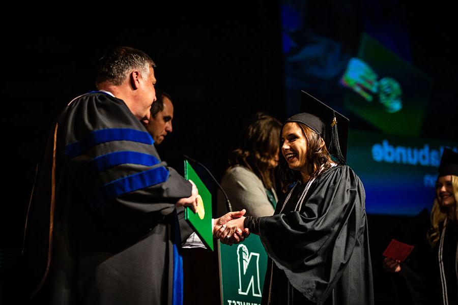 A Northwest graduate crosses the stage in Bearcat Arena during a commencement ceremony. (Northwest Missouri State University photo)